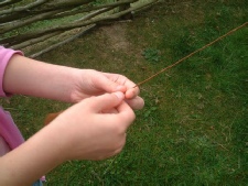 Close up of child making natural cordage